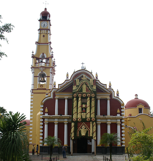 Photo: Arcos in front of church and man sweeping up saw dust