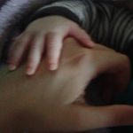 Picture of small hand resting on bigger hand